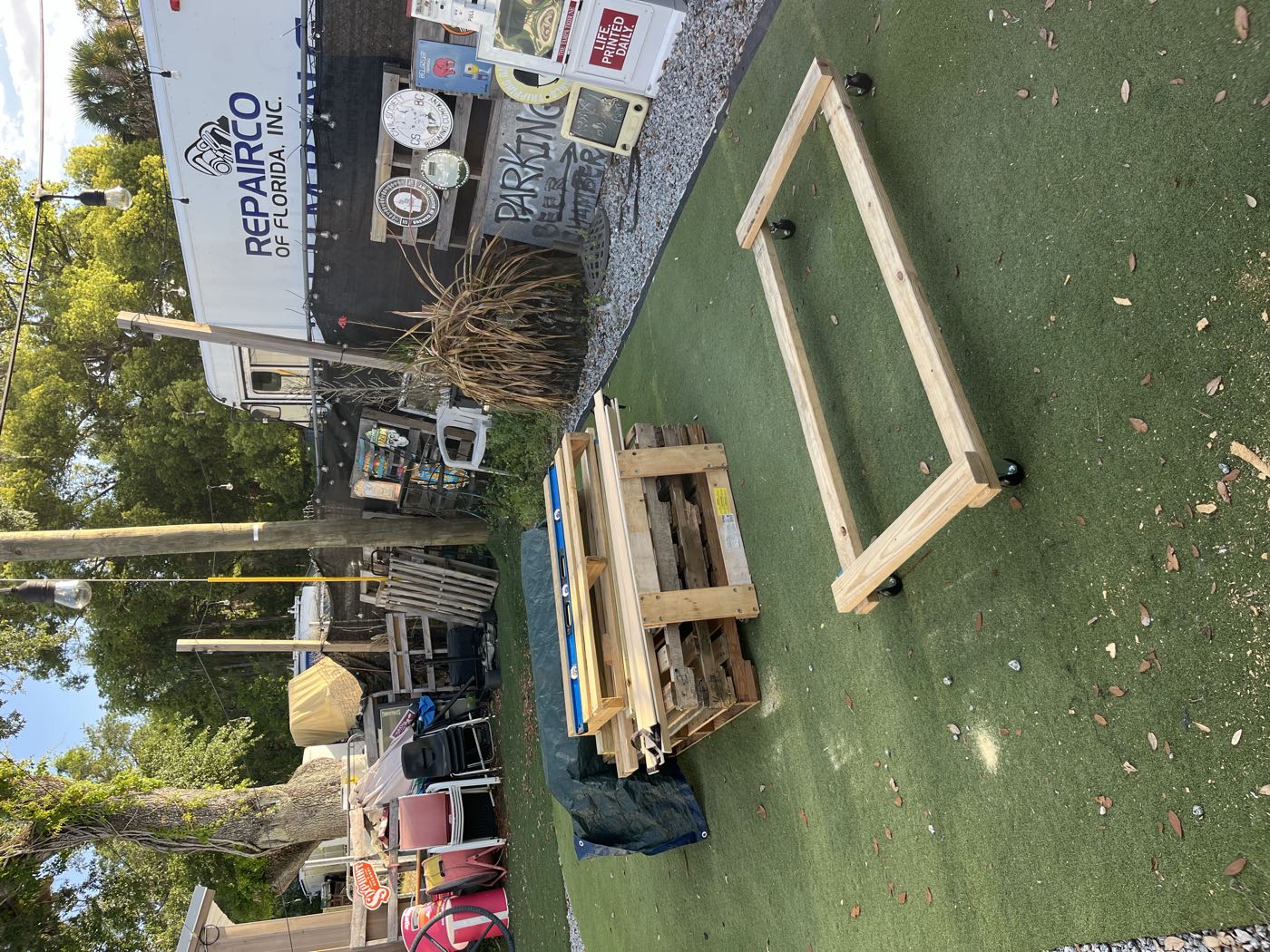 A rectangular base frame on casters next to a stack of pallets