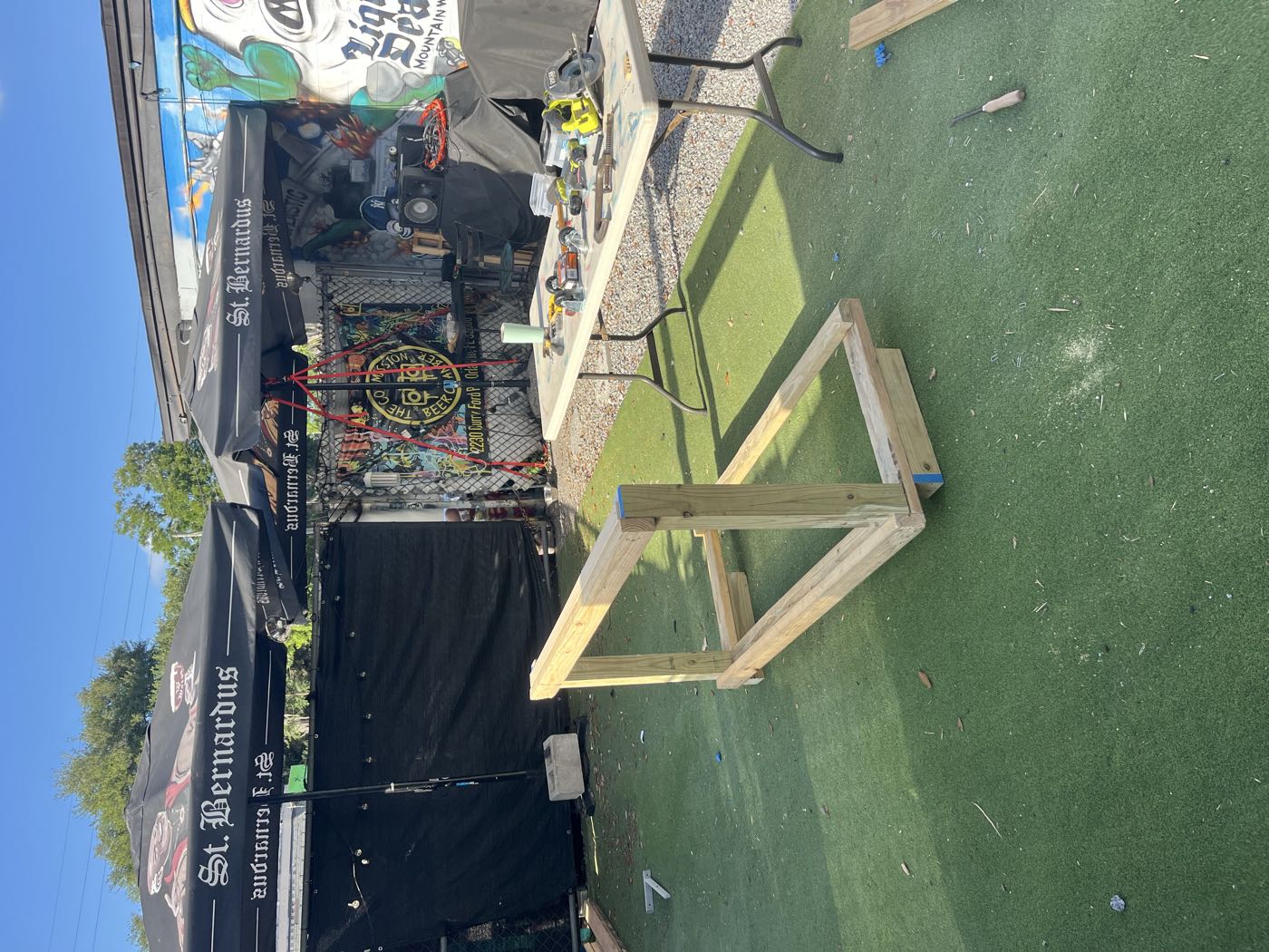 The frame up on folding work tables under a tent, being squared