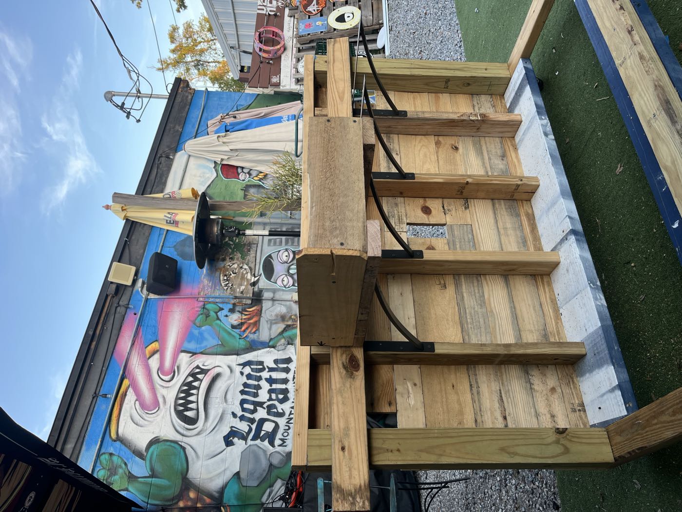 The front face of the booth clad in pallet boards, mural behind